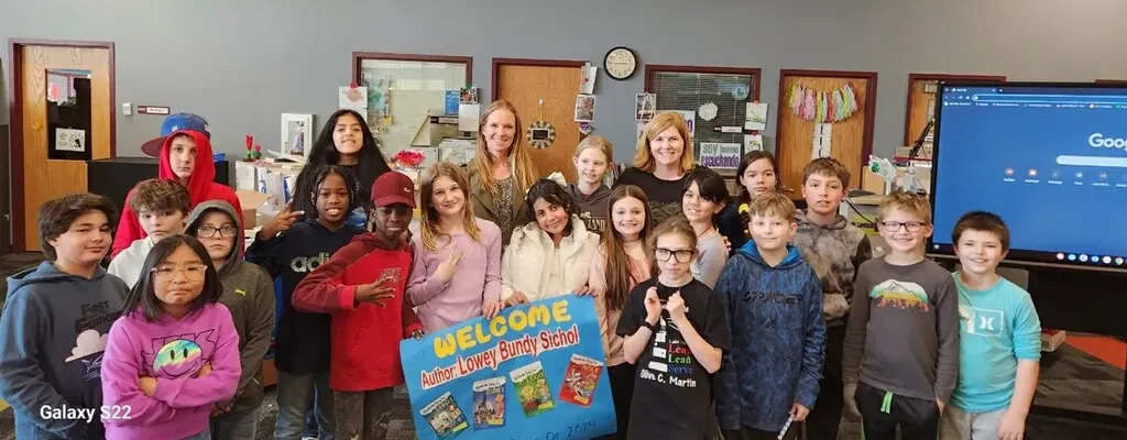 Lowey Bundy Sichol posing with students and teachers during an elementary school author visit.
