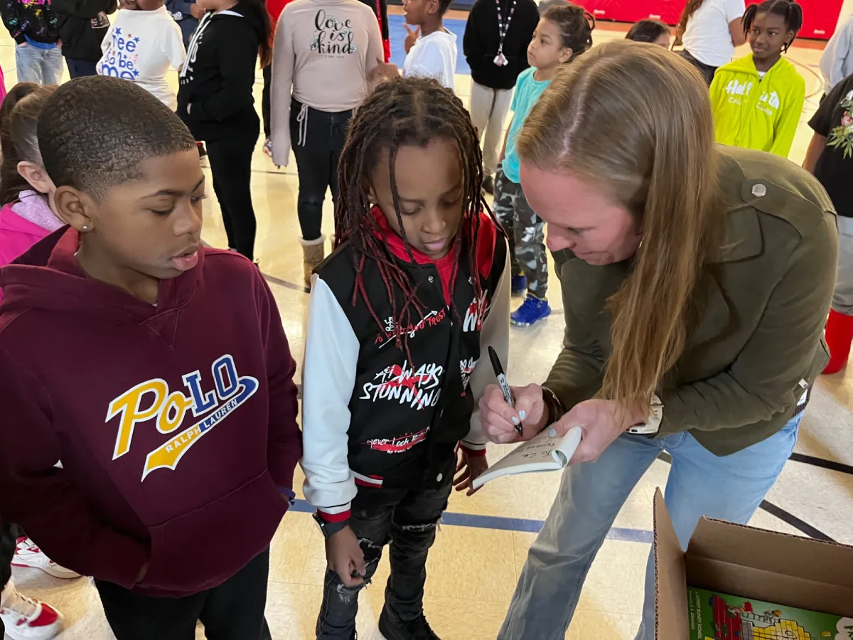 Lowey Bundy Sichol signing a book for a student during an elementary school author visit.