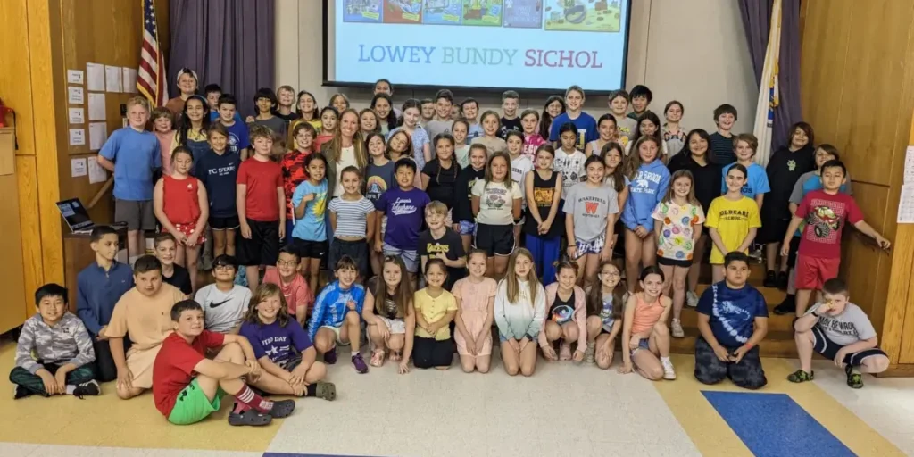 Lowey Bundy Sichol posing with students and teachers during an elementary school author visit.